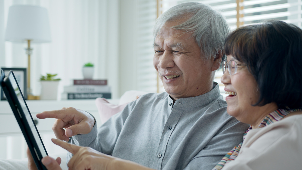 Two seniors use technology to connect with family.