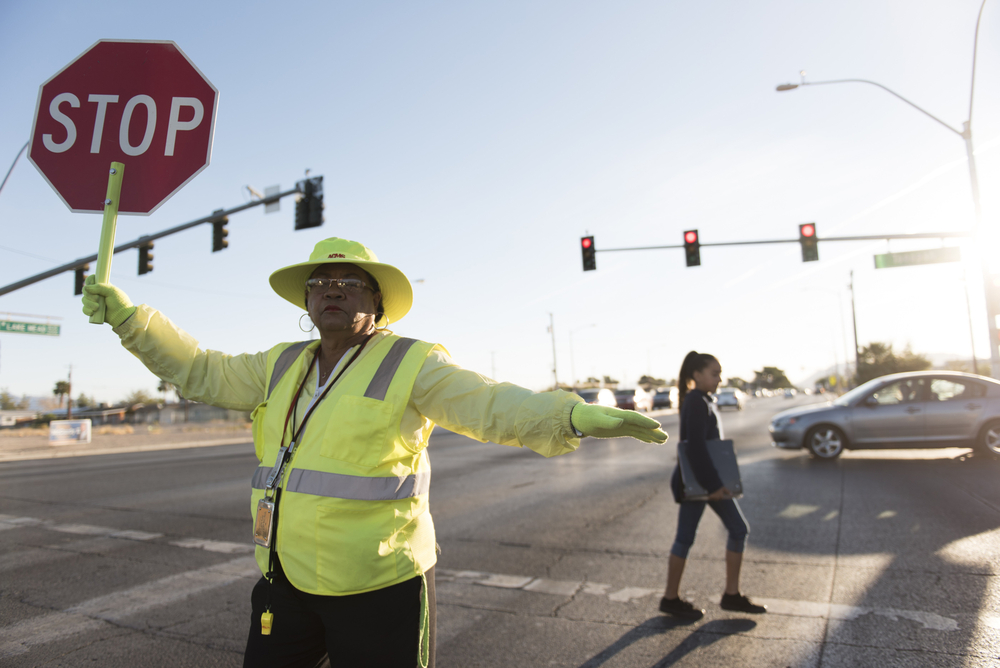 A crossing guard helps children cross a street safely.