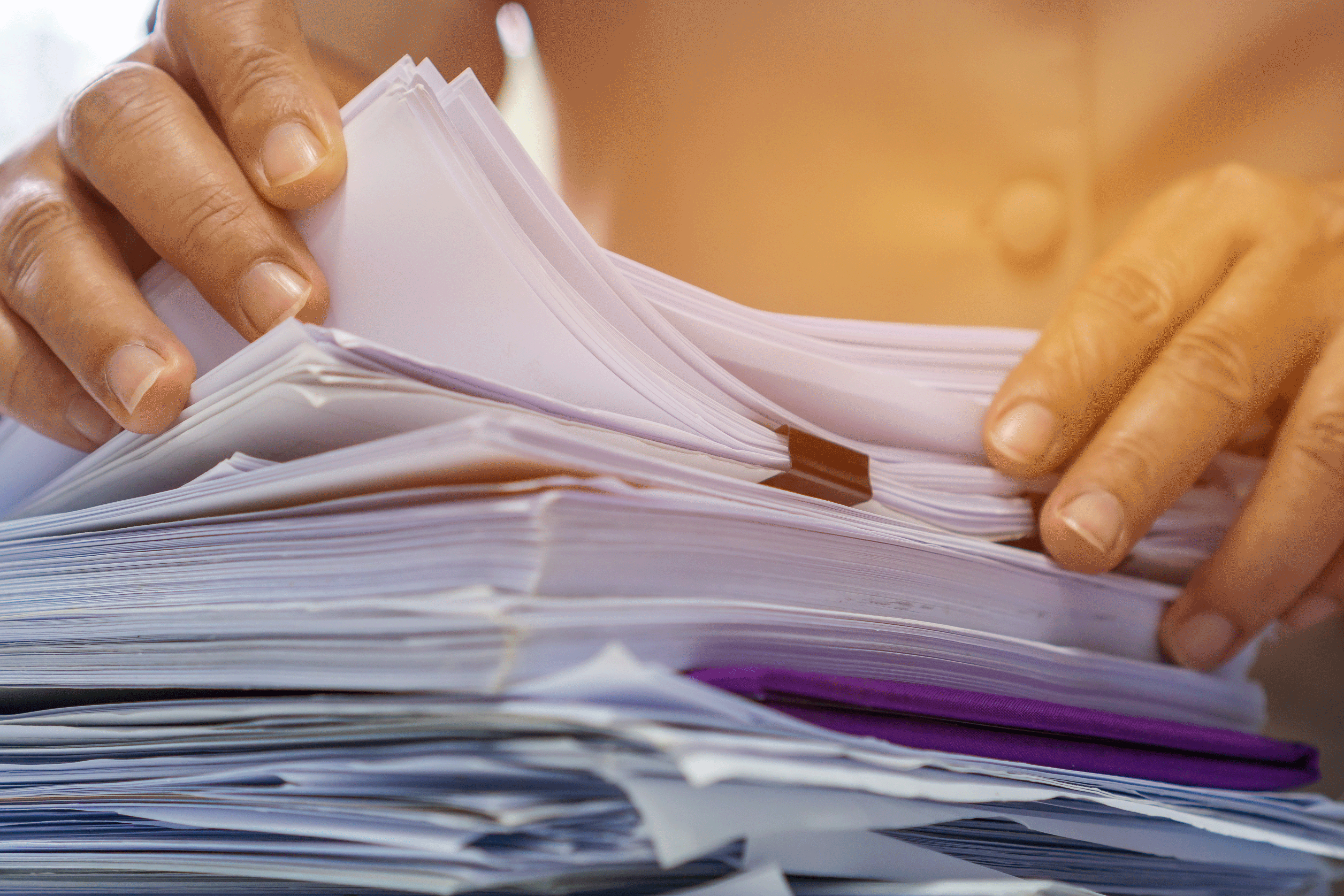 A woman sifts through a stack of papers.