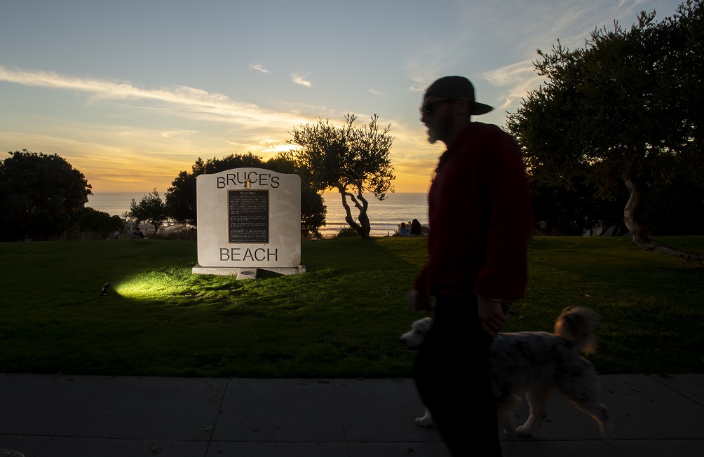 A person passes the Bruce's Beach monument at sunset.