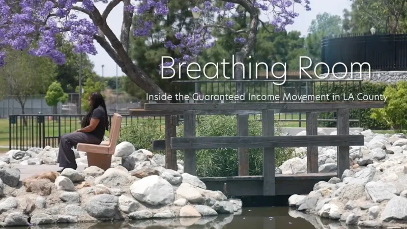 A woman sits on a bench under a blooming jacaranda tree. The text says Breathing Room: Inside the Guaranteed Income Movement in LA County.