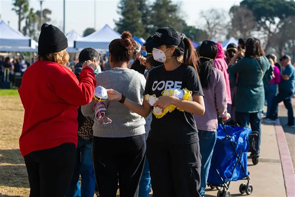 A person handing out face masks